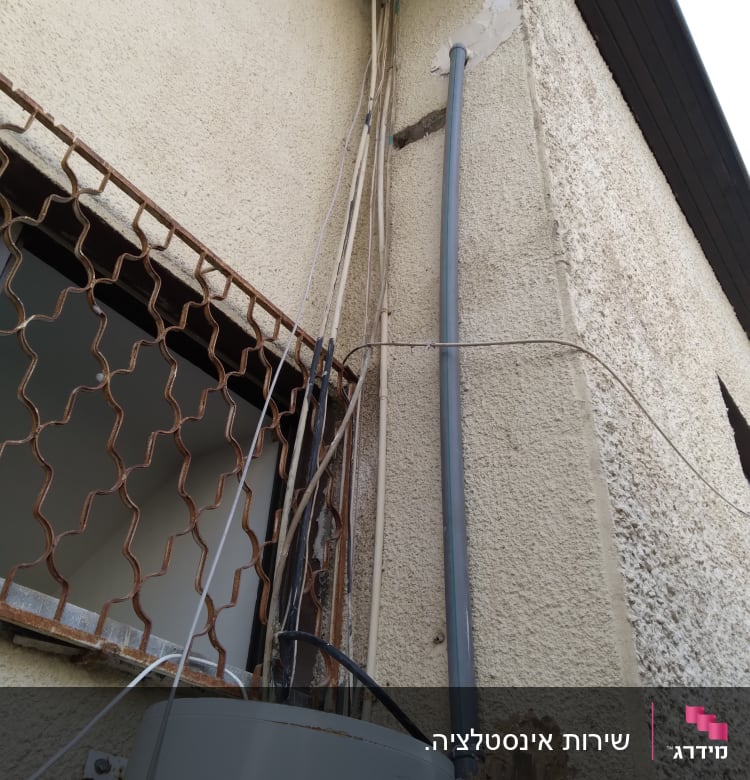 צינור מים מחובר לדוד חיצוני על קיר